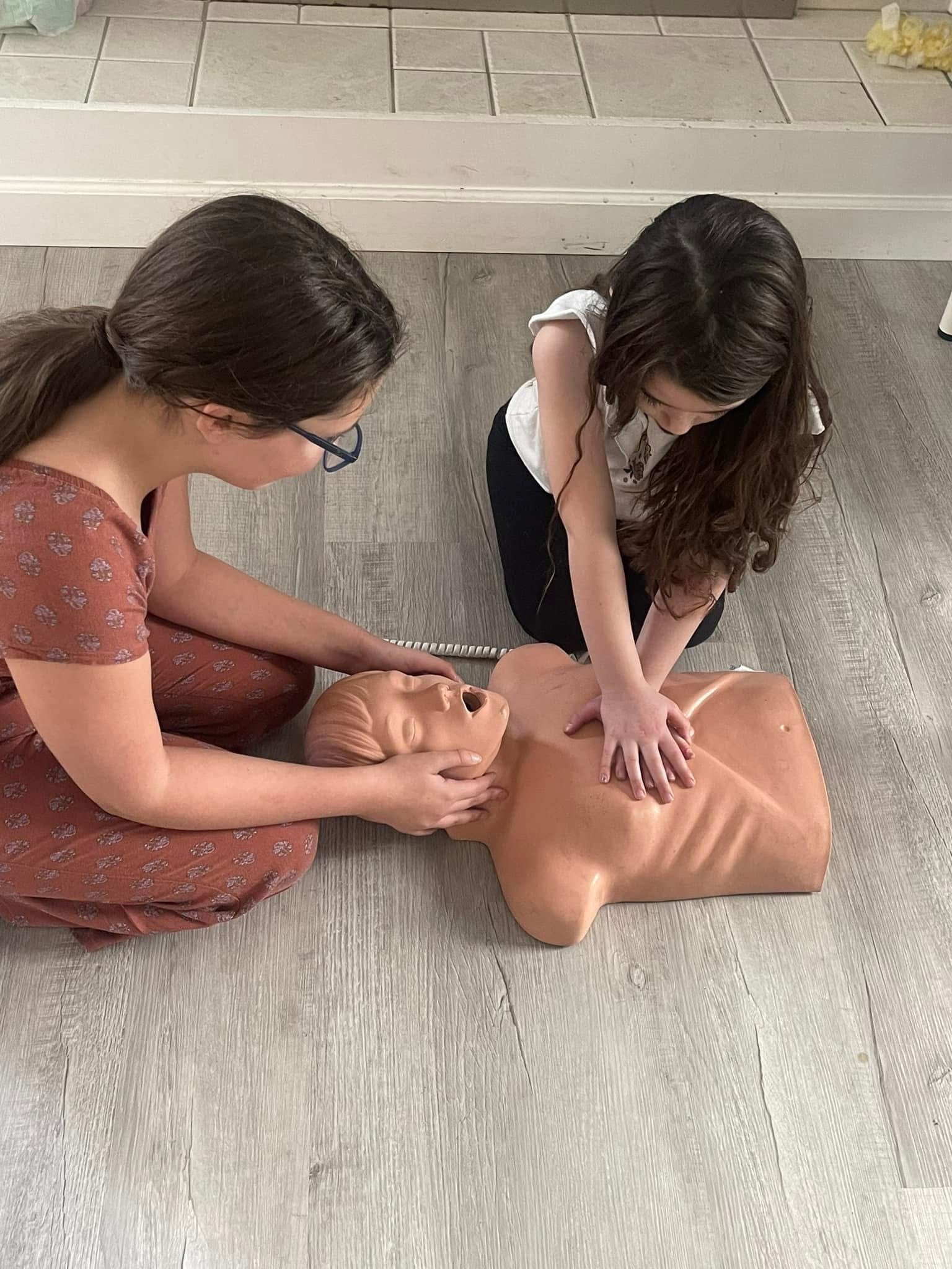 Students practicing adult CPR on manikin