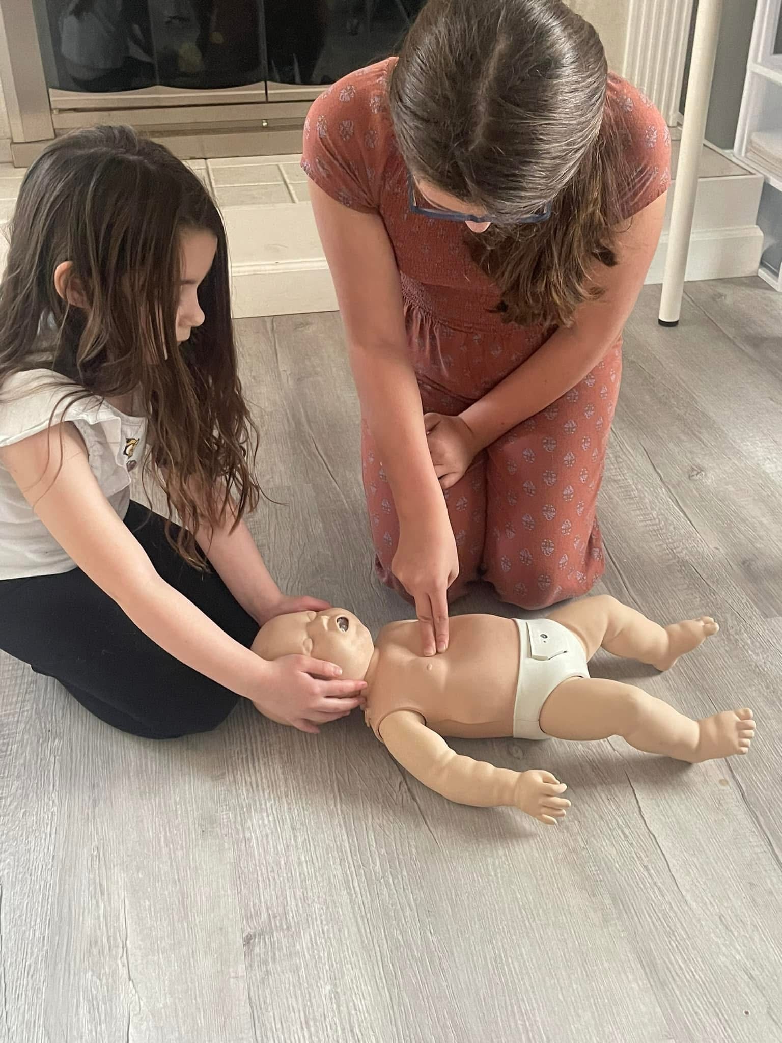 Students practicing infant CPR on baby manikin